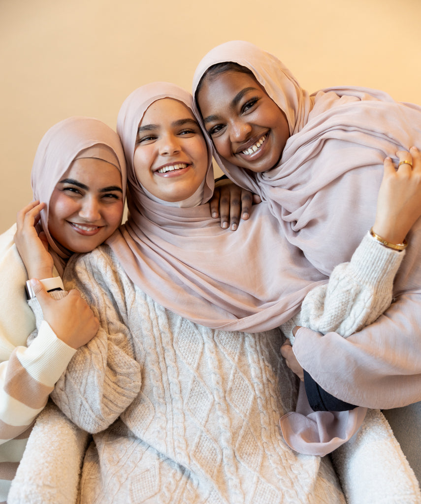three women in a group photo wearing modal hijab in different sizes in a truffle mushroom light sand stone tan shade