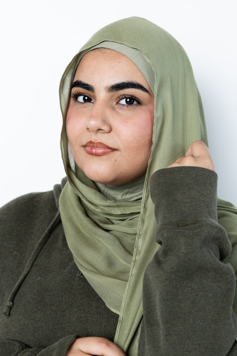 woman wearing modal hijab in different sizes in an olive green tone