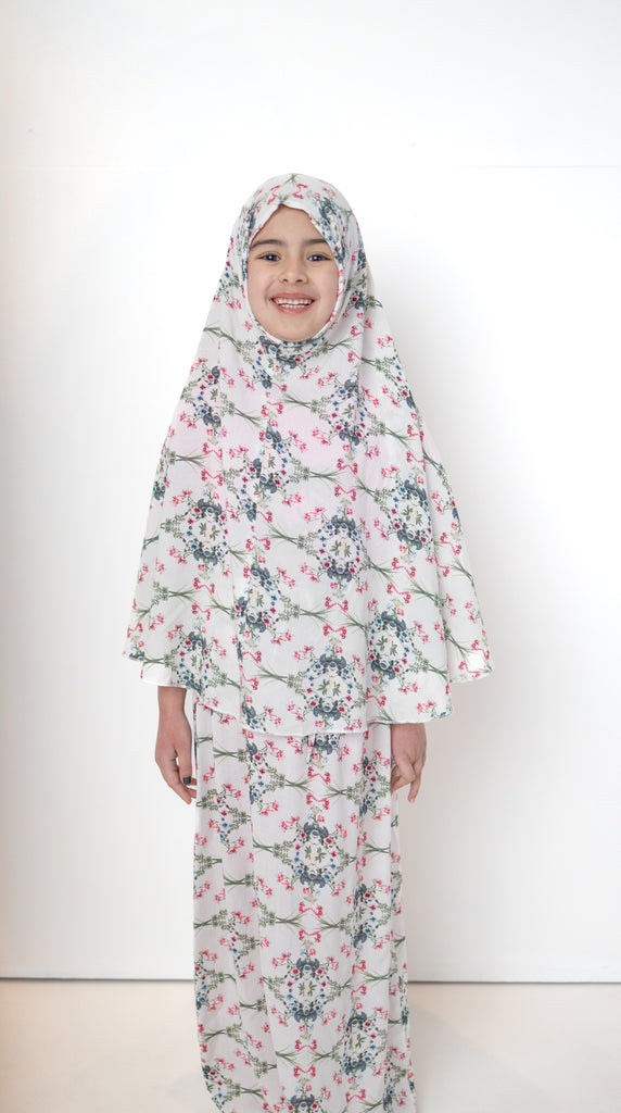 two piece salah outfit with hijab and skirt printed with pink, green, and white floral