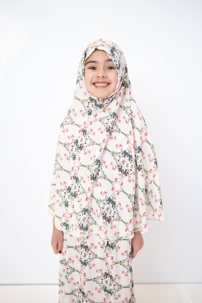 two piece salah outfit with hijab and skirt printed with pink, green, and white floral