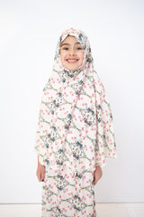 two piece salah outfit with hijab and skirt printed with pink, green, and white floral