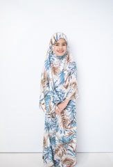 two piece salah outfit with hijab and skirt printed with blue, white, and beige leaves