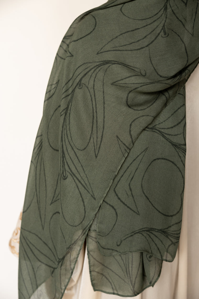 woman wearing olive green modal print hijab with olives and olive leaves branches Palestinian design