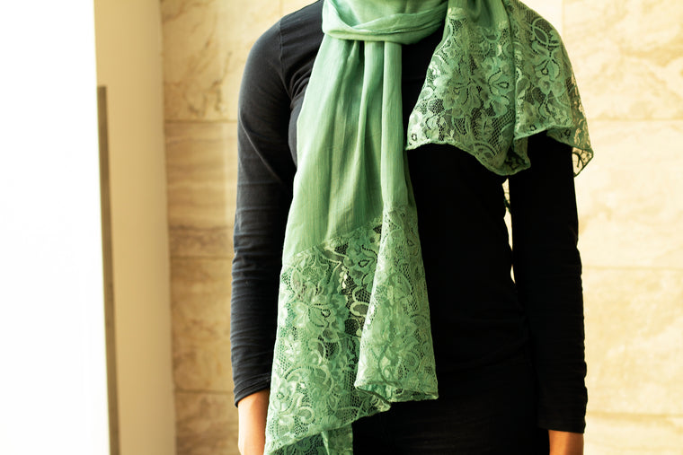 solid light green hijab made with modal fabric and embellished with lace at the ends