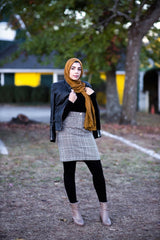 muslim woman wearing a mocha brown modal lace hijab modal hijab with lace on the ends and a leather bomber jacket and pencil checkered skirt