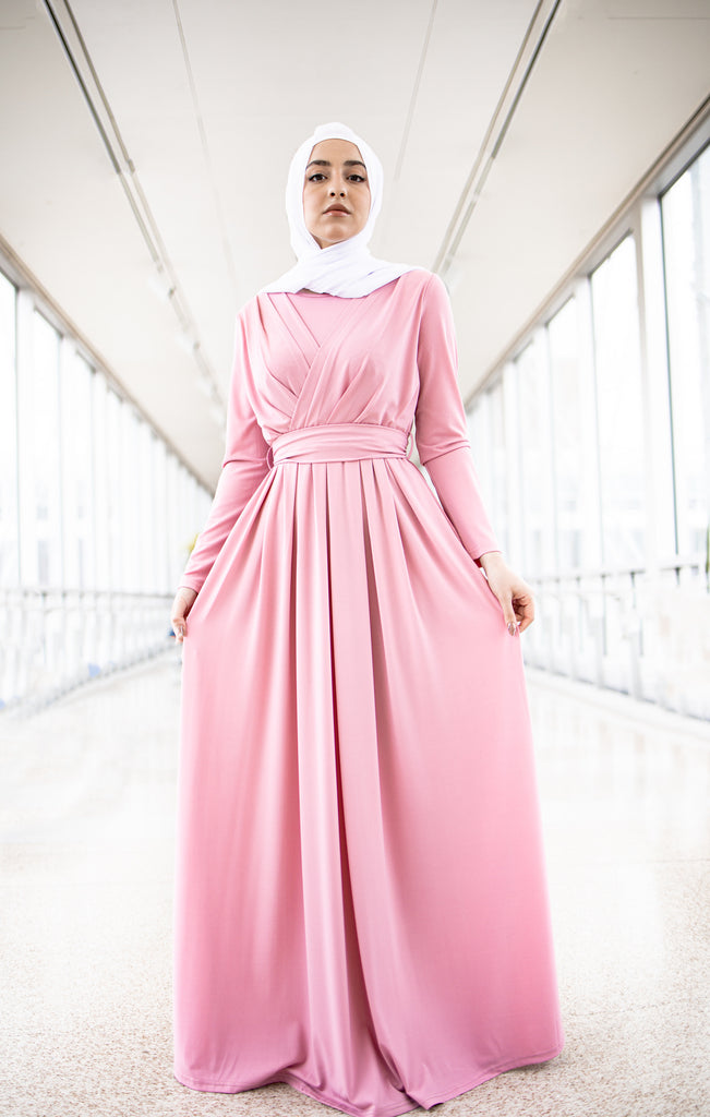 muslim woman wearing a criss cross pink long sleeve elegant maxi dress with a white chiffon hijab