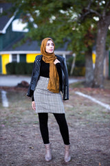 muslim woman wearing a mocha brown modal lace hijab modal hijab with lace on the ends and a leather bomber jacket and pencil checkered skirt