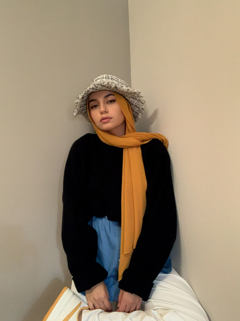 muslim hijabi woman wearing sunflower yellow chiffon hijab and denim button down shirt extension