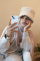 woman wearing modal hijab in different sizes in a truffle mushroom light sand stone tan shade with a sherpa hat taking a selfie in a knit sweater pinterest look