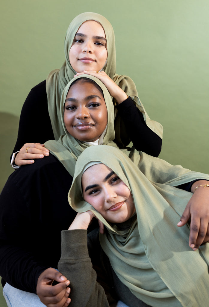 three women wearing modal hijabs in different sizes in an olive green tone 