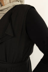 black cascade sleeveless vest with a waist belt and pocketsmuslim woman wearing a black sleeveless cascade jacket with zipper pockets and a blue shimmer jersey hijab