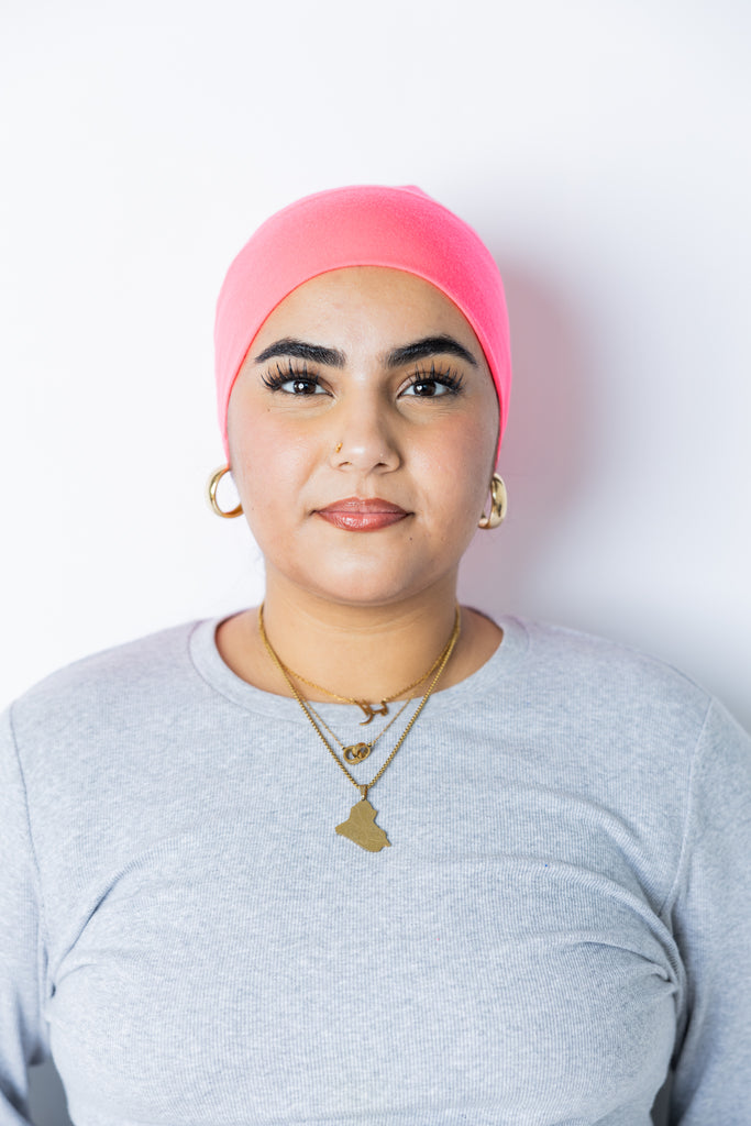 a woman wearing a neon pink undercap for hijab