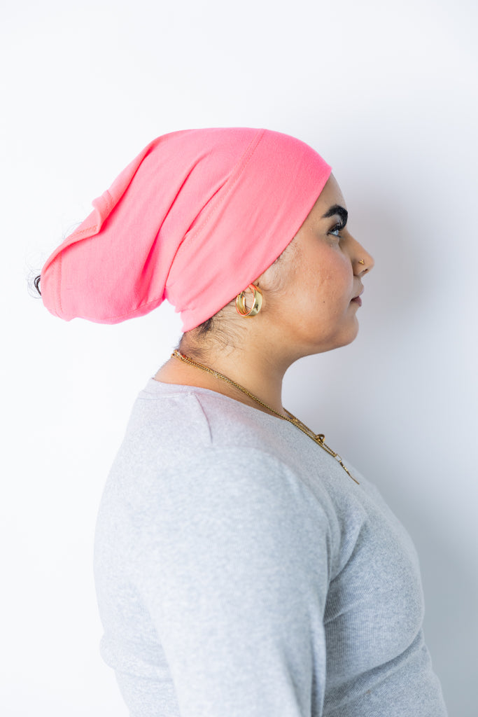 a woman wearing a neon pink undercap for hijab