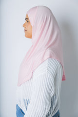 a woman wearing a light pink jersey slip on one piece hijab