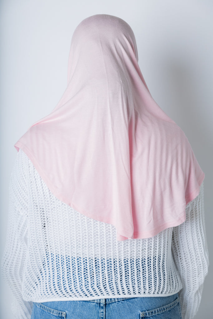 a woman wearing a light pink jersey slip on one piece hijab