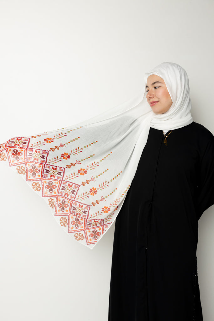 woman wearing white modal hijab with tatreez Palestinian pattern motifs 