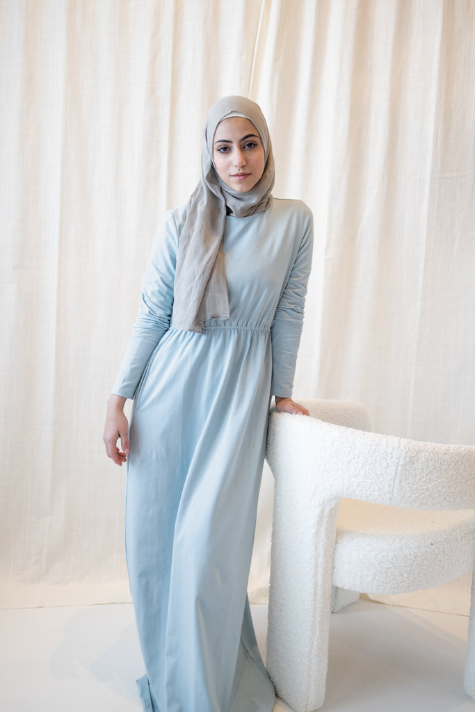 muslim woman in a light blue long sleeved maxi dress