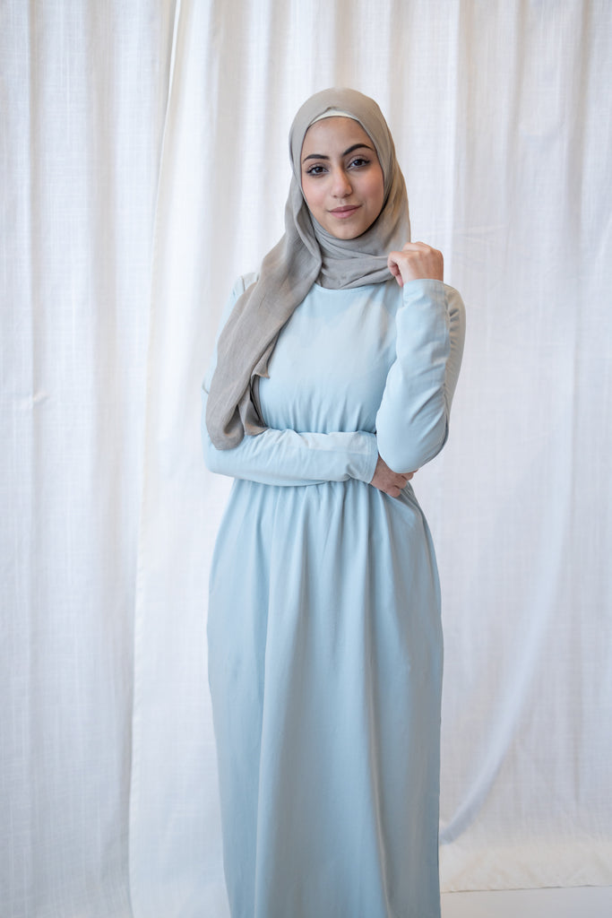 muslim woman in a light blue long sleeved maxi dress