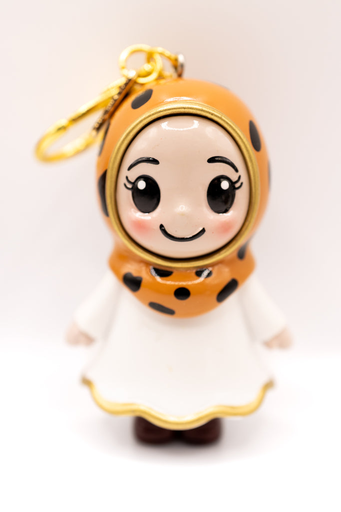 light skinned hijabi figurine in cheetah print hijab on golden keychain