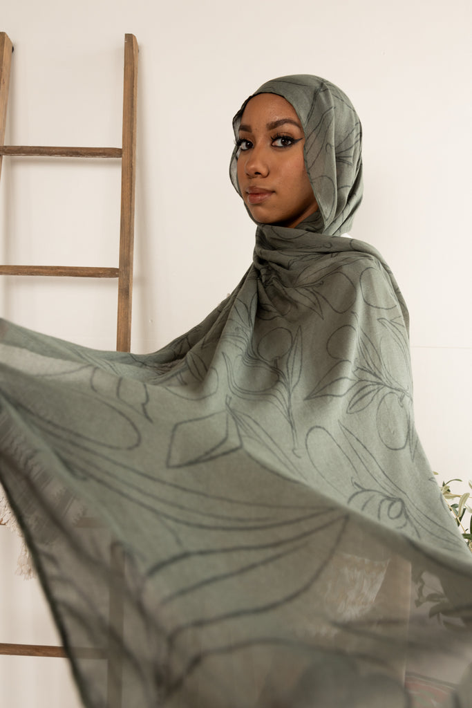 woman wearing olive green modal print hijab with olives and olive leaves branches Palestinian design 