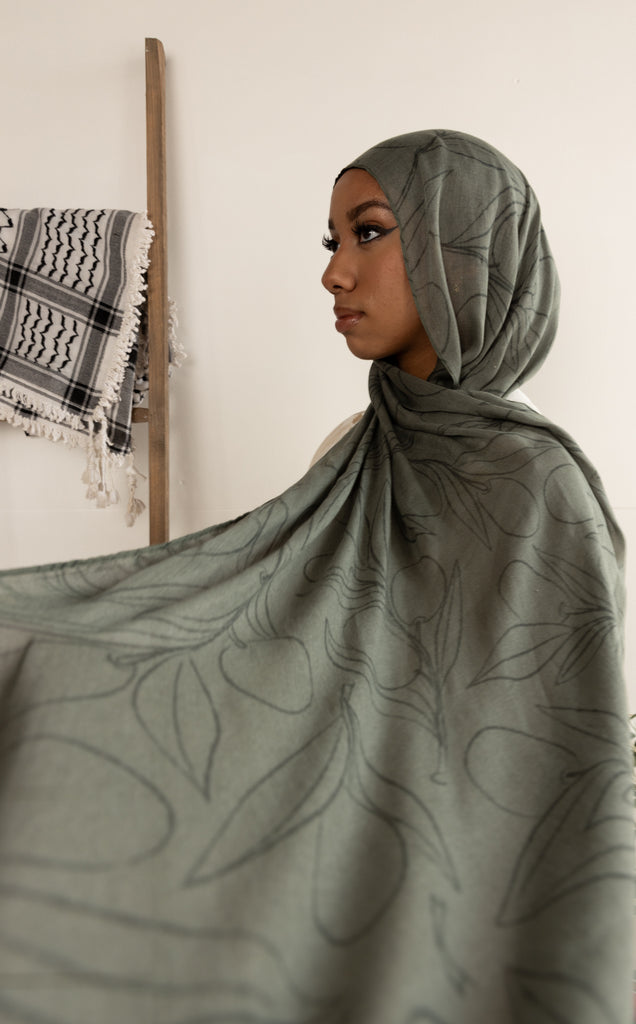 woman wearing olive green modal print hijab with olives and olive leaves branches Palestinian design 