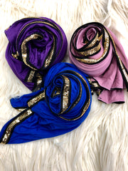 three jersey hijabs embellished with a gold metal trim in purple, blush, and royal blue