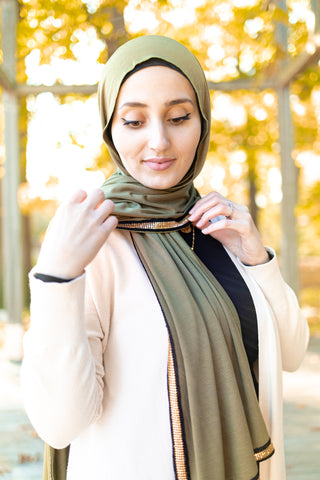 olive jersey hijab embellished with a gold trim along the edges  