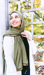 olive jersey hijab embellished with a gold trim along the edges 