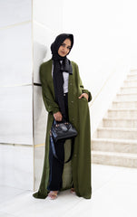 muslim woman wearing a beige long sleeve maxi dress with a long sleeve satin olive textured abaya with a waist tie and pockets