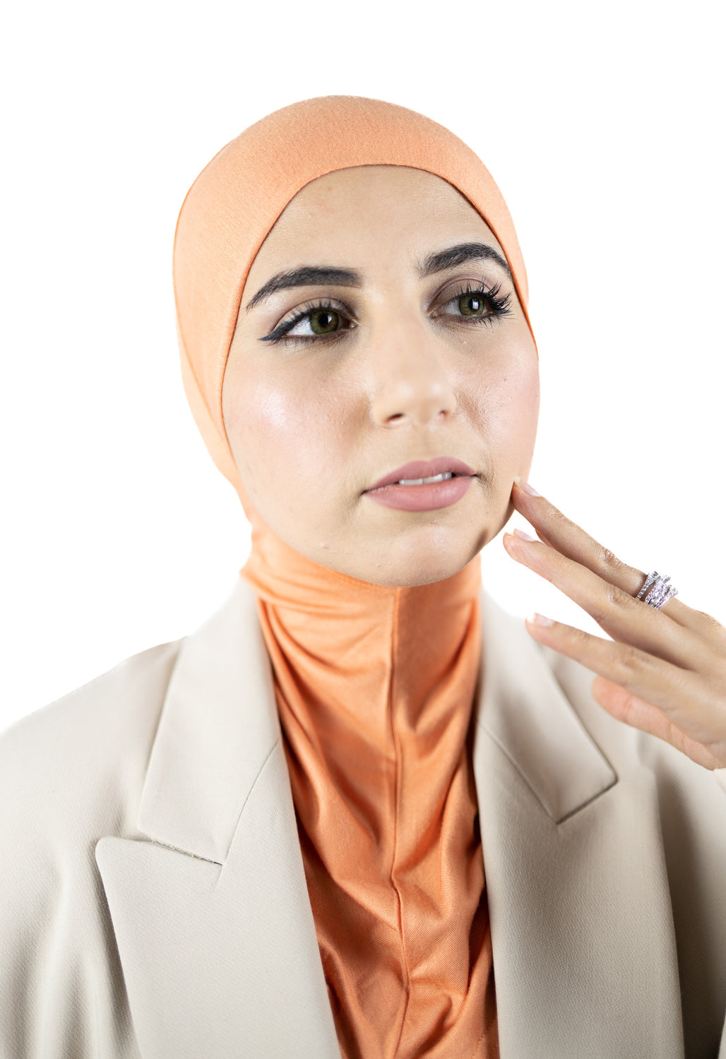 muslim woman wearing a beige blazer and mango orange ninja underscarf