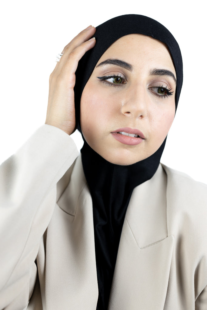 muslim woman wearing a beige blazer and black ninja underscarf