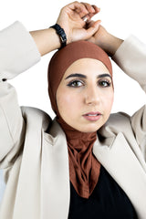 muslim woman wearing a beige blazer and burnt orange ninja underscarf