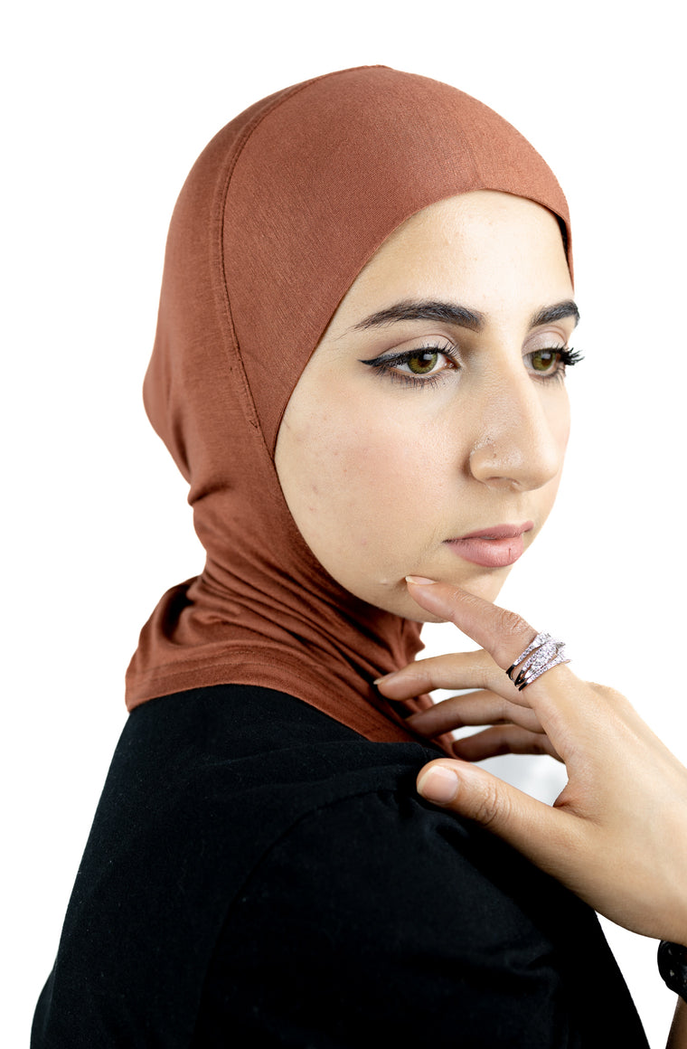 muslim woman wearing a beige blazer and burnt orange ninja underscarf