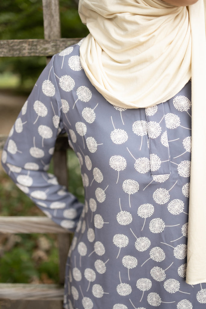 gray dandelion printed top with simple elastic sleeves, a collar, and three buttons  Edit alt text