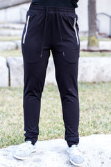 a woman wearing black jogger pants with gold zippers and drawstring 