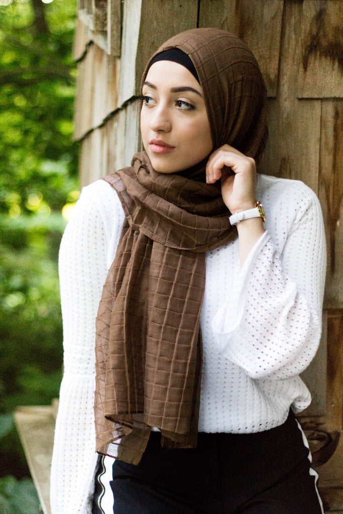 muslim woman wearing a white textured top and black pants with a mocha brown color textured hijab