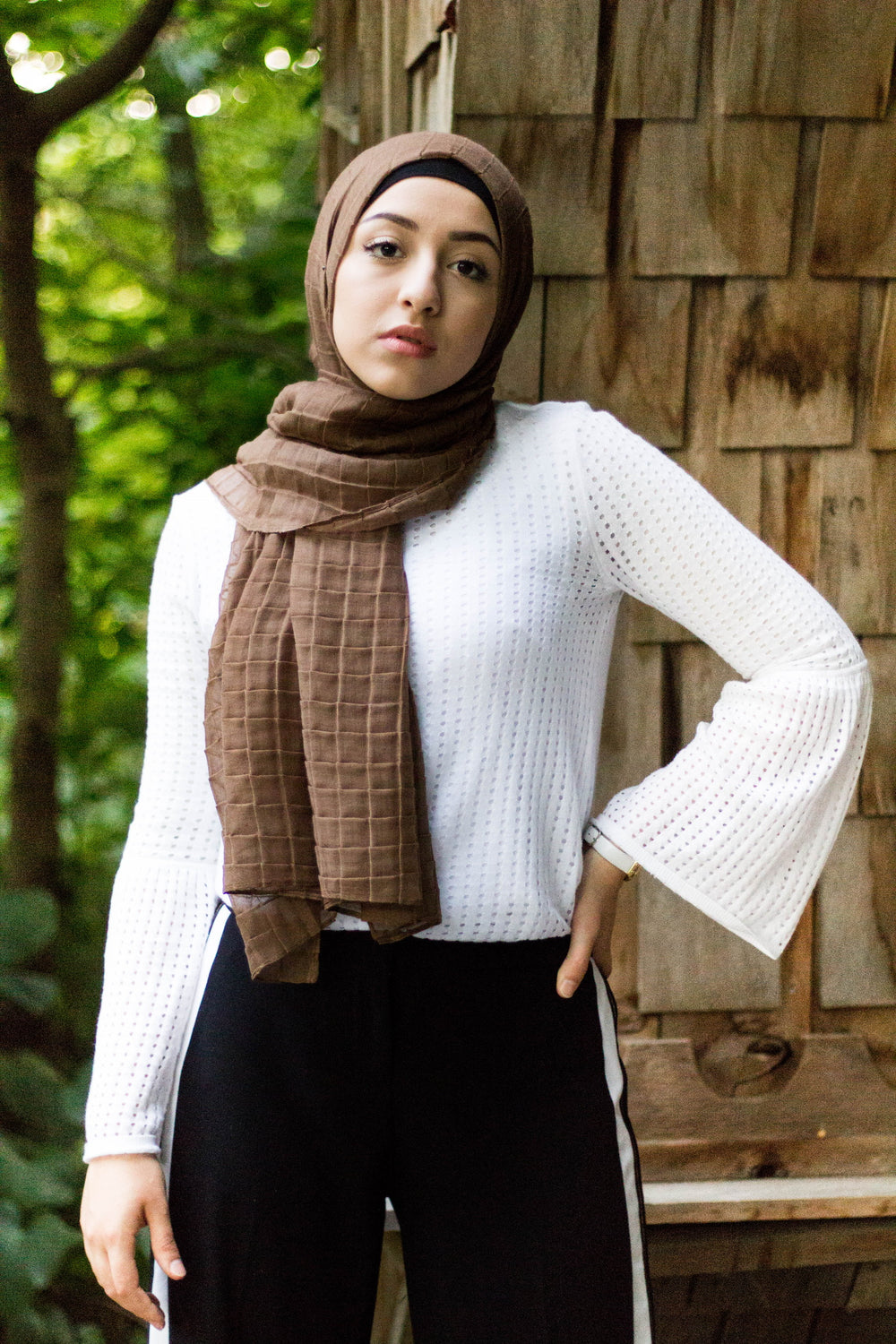 muslim woman wearing a white textured top and black pants with a mocha brown color textured hijab