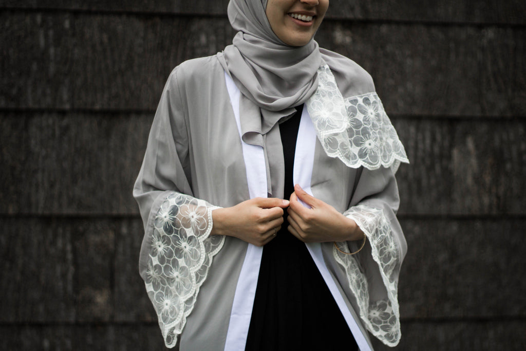 woman wearing an abaya in silver embellished with lace sleeves and a matching hijab