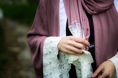 woman wearing an abaya in mauve embellished with lace sleeves and a matching hijab