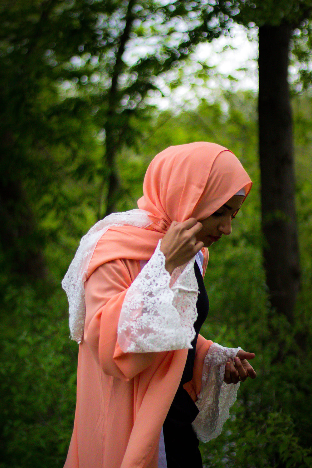 woman wearing an abaya in salmon embellished with lace sleeves and a matching hijab