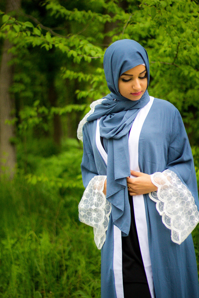 woman wearing an abaya in blue embellished with lace sleeves and a matching hijab