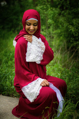 woman wearing an abaya in red embellished with lace sleeves and a matching hijab
