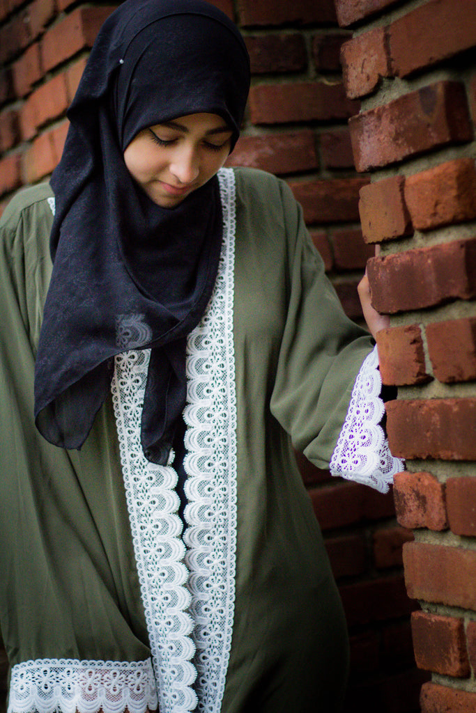 woman wearing an abaya in olive green embellished with white lace sleeves