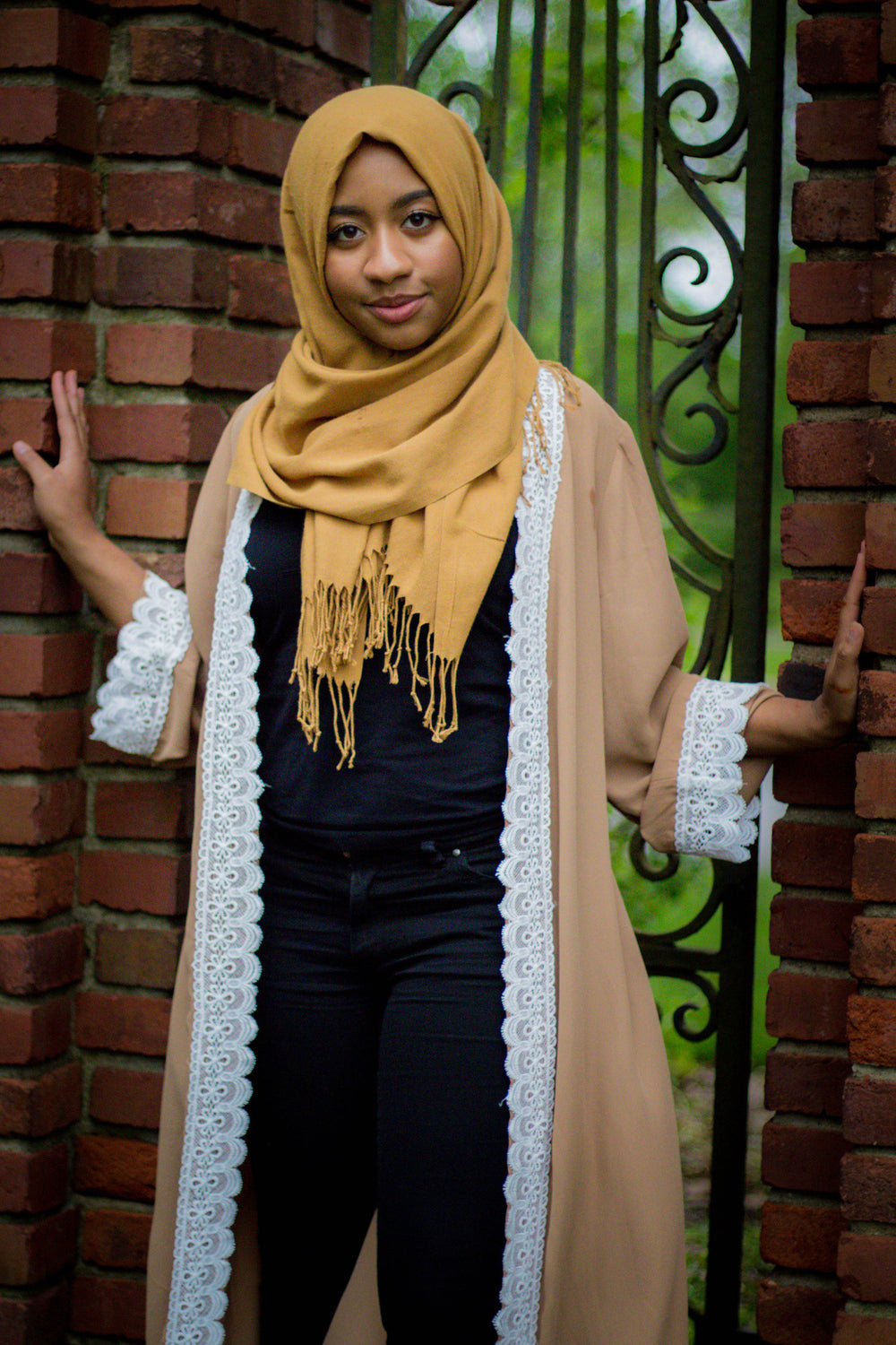 woman wearing an abaya in tan embellished with white lace sleeves