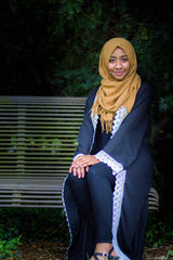 woman wearing an abaya in black embellished with white lace sleeves