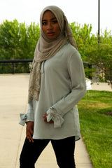 black muslim woman in bow sleeve top in mint and gray lace hijab