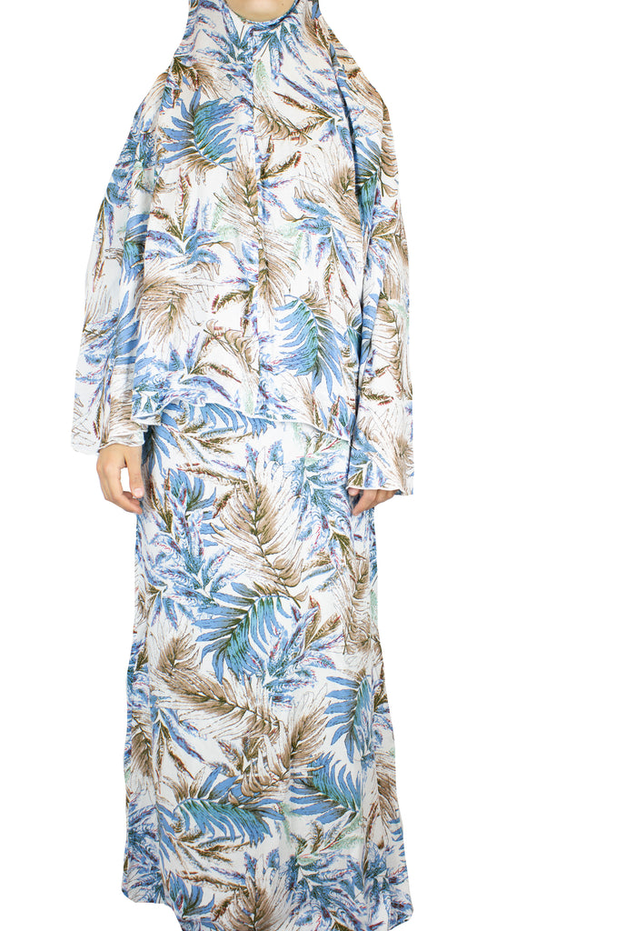 two piece salah outfit with hijab and skirt printed with blue, white, and beige leaves