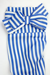 large bow on striped sleeves of a white and blue blouse