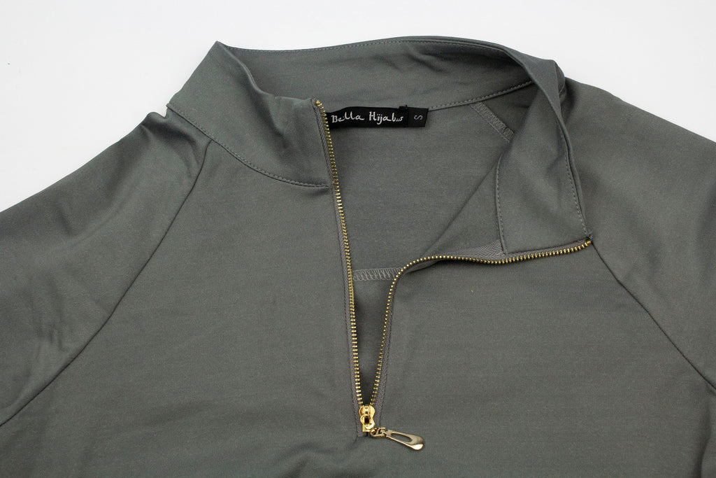 close up of long modest top with a gold zipper and bella hijabs tag