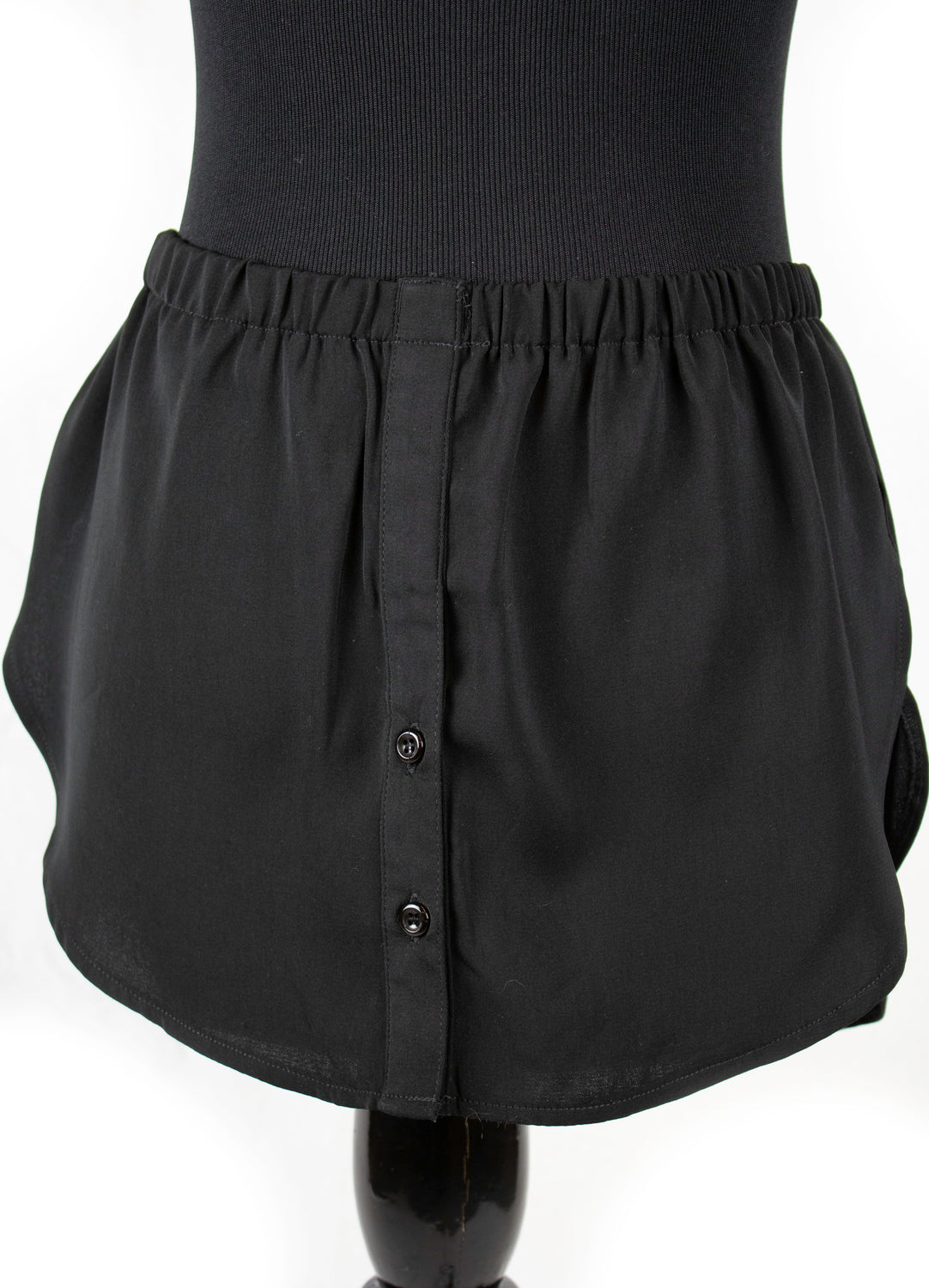 fake shirt extender in black with buttons and an elastic waistband